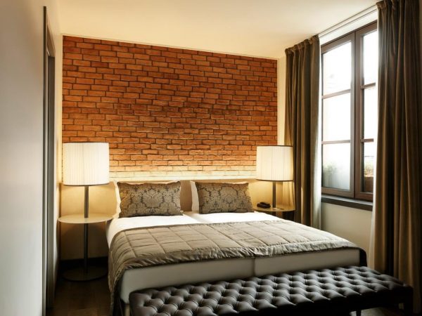 Oświetlona ściana z cegły w sypialni