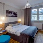 Sypialnia z białą cegłą na ścianie i dużym łóżkiem