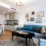 Duży jasny salon z kuchnią w stylu klasycznym z aranżacją ściany przy użyciu starej białej cegły gipsowej.