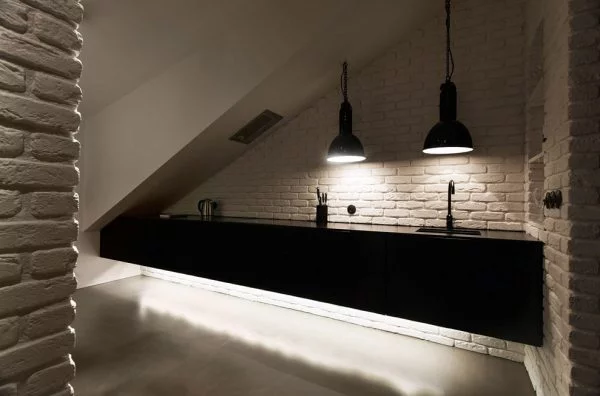 Czarna kuchnia ze ścianą z białej cegły